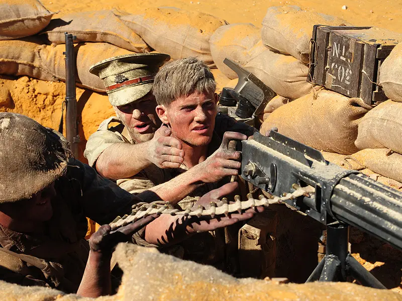 two soldiers in trench firing machine gun