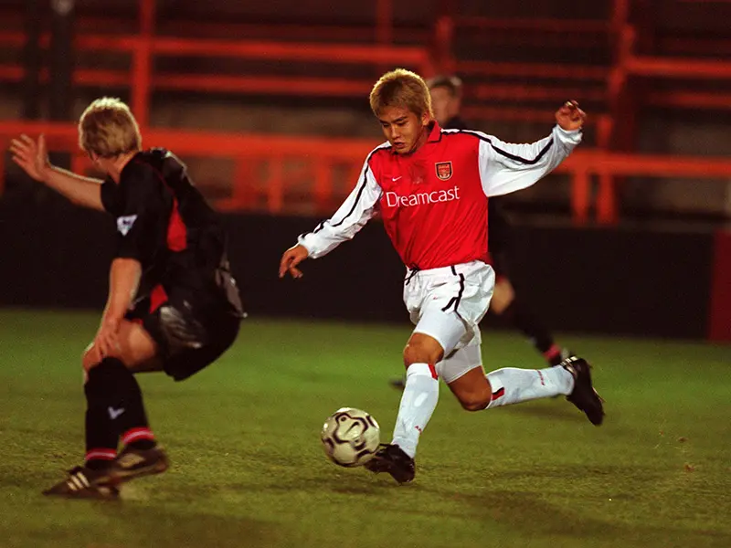 Japanese football player Junichi Inamoto kicking a ball mid game