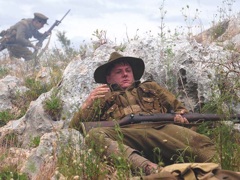 Archie Barwick lying down with gun on battlefield WW1