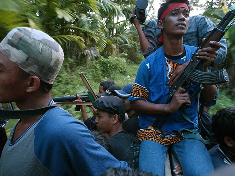 Achenes rebels ride through jungle on truck holding weapons