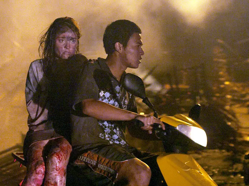 Victims of Bali terrorist bombing flee wreckage on a scooter injured