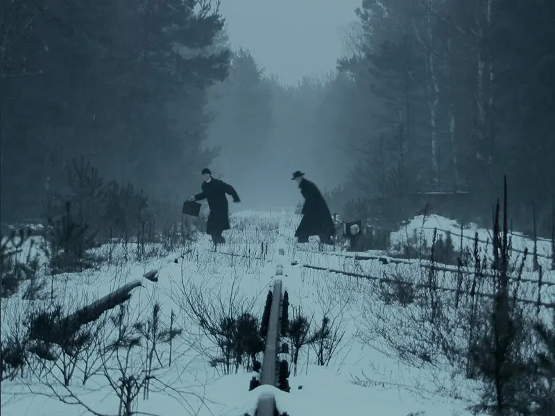 Great Escape escapees played by actors Grzegoi Steinzinper and Przemyslaw Terpinski flee on foot in snow across train tracks